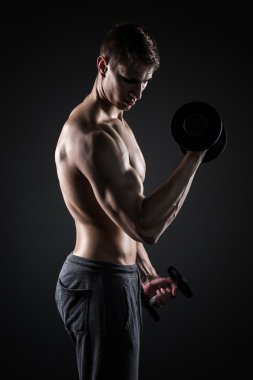 Kaslı adam, pazı dumbbells ile yapıyor çalışma