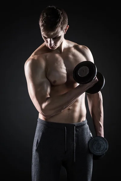 Homme avec torse nu et haltères sur fond noir — Photo