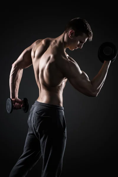 Γυμναστήριο άνθρωπος κάνει ασκήσεις με αλτήρες στο δικέφαλους, πίσω όψη — Φωτογραφία Αρχείου