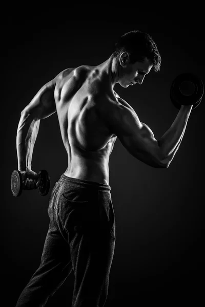 Hombre de fitness haciendo ejercicios con pesas en bíceps, vista trasera —  Fotos de Stock