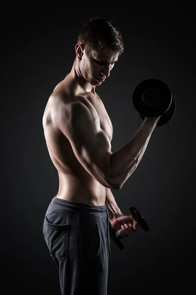Homem muscular trabalhando fora fazendo exercícios com halteres no bíceps — Fotografia de Stock