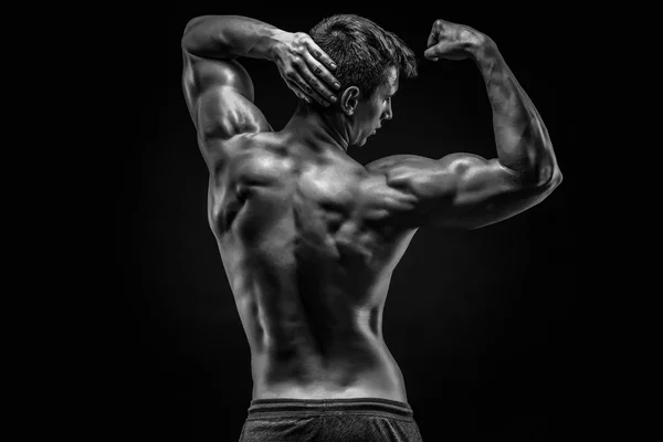 Joven musculoso sano mostrando músculos de la espalda y del bíceps — Foto de Stock