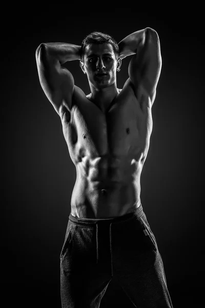 Sexig bar överkropp bodybuilder poserar, titta på kameran på svart ba — Stockfoto