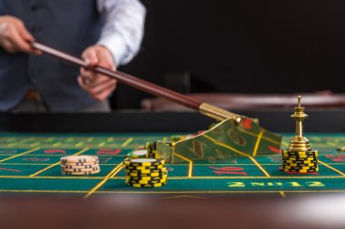Stick kullanarak casino krupiye topladığı fişleri.