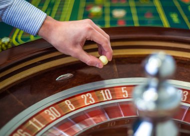 Rulet tekerleği ve krupiye casino beyaz topu eliyle