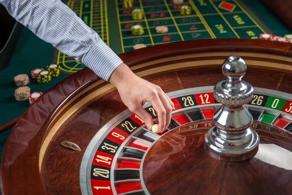 Rueda de ruleta y mano croupier con bola blanca en casino —  Fotos de Stock