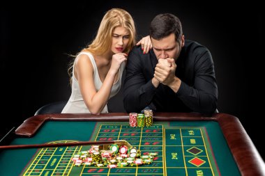 Kumarhanede Rulet oynayan kadınlar ile erkekler.