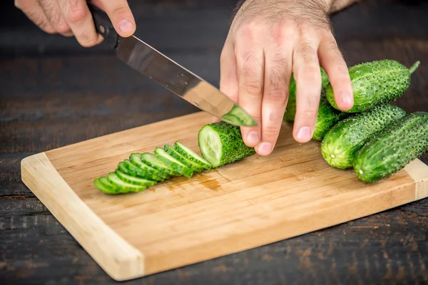 Мужские руки режут овощи для салата — стоковое фото