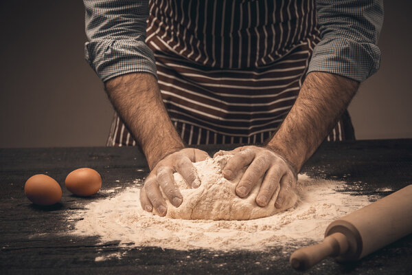 Мужские руки месят тесто
.