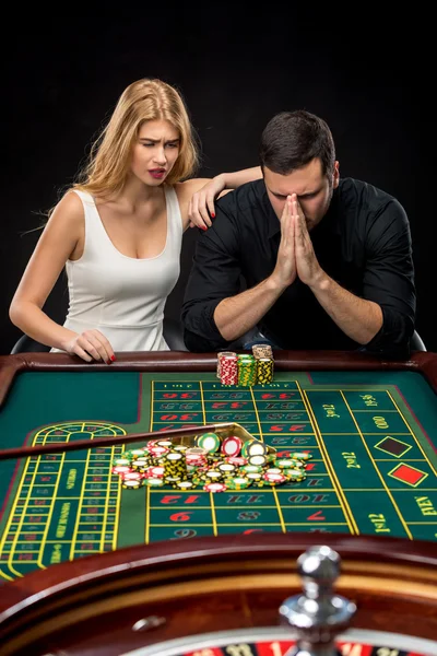 Männer mit Frauen spielen Roulette im Casino. — Stockfoto