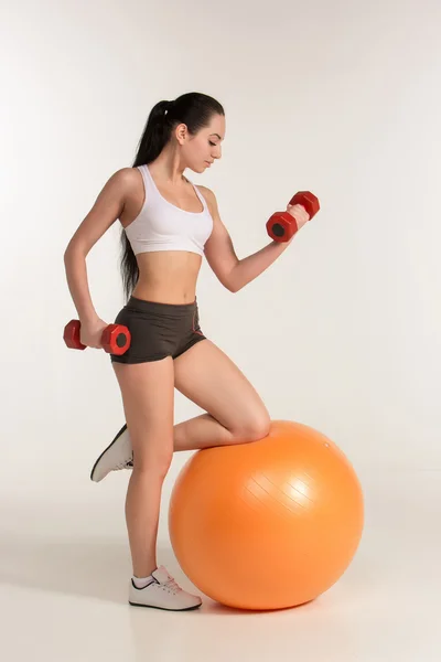 Jonge mooie Sportvrouw met halters uitoefenen op fitball — Stockfoto