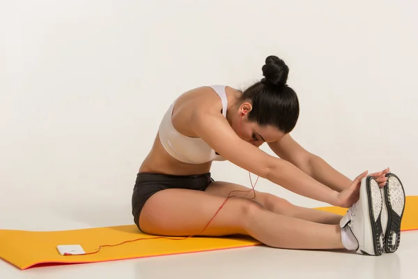 Femme attrayante faisant des exercices. Brunette fit corps sur tapis de yoga — Photo