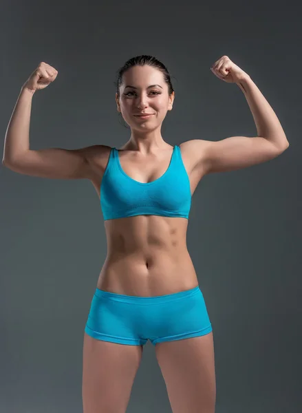 Young athletic girl shows muscles — Stock Photo, Image