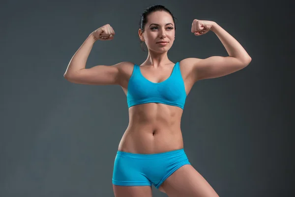 Молодая атлетичная девушка показывает мышцы — стоковое фото