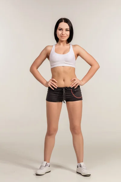 Mujer joven deportiva en pantalones cortos y top — Foto de Stock