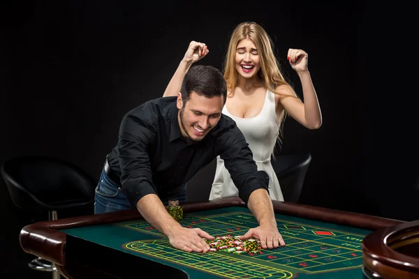 Młoda para z okazji wygrać w ruletkę w kasynie. — Zdjęcie stockowe
