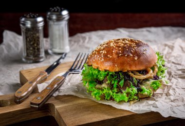 Devekuşu burger, soğan, sos ve salata ile sandviç