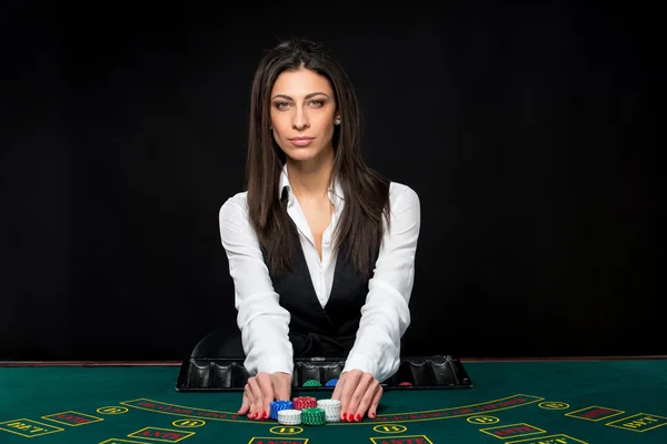 A menina bonita, negociante, atrás de uma mesa do pôquer — Fotografia de Stock