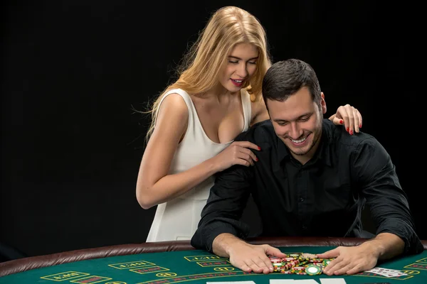 玩扑克的年轻夫妇。获胜后以扑克筹码的男人 — 图库照片