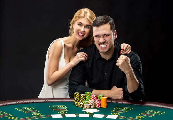 Junges Paar, das Poker spielt, hat eine gute Zeit im Casino — Stockfoto