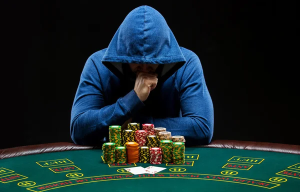 Retrato de um jogador profissional de poker sentado à mesa de pôquer — Fotografia de Stock