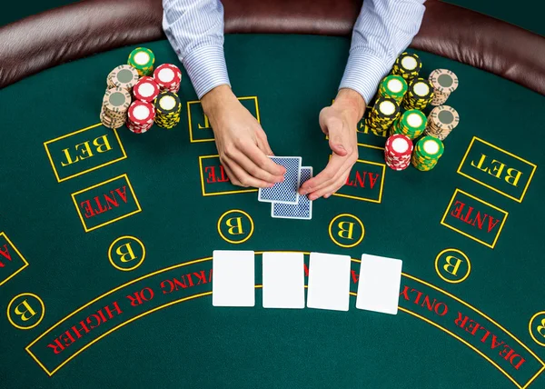 Closeup of poker player with playing cards and chips — Stock Photo, Image