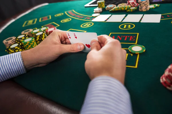 Jogador de poker masculino segurando o de duas cartas ases — Fotografia de Stock