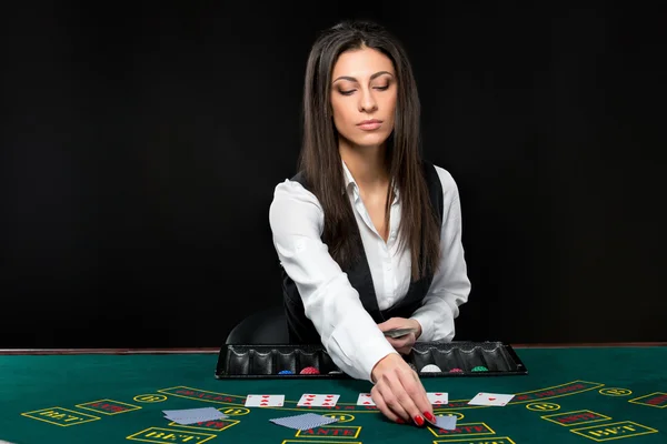 A gyönyörű lány, kereskedő, mögött egy táblázatot a póker — Stock Fotó