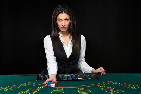 A menina bonita, negociante, atrás de uma mesa do pôquer — Fotografia de Stock