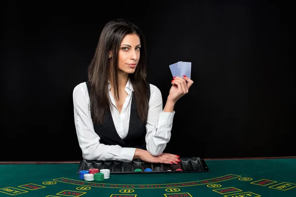 Den vackra flickan, återförsäljare, bakom ett bord för poker — Stockfoto