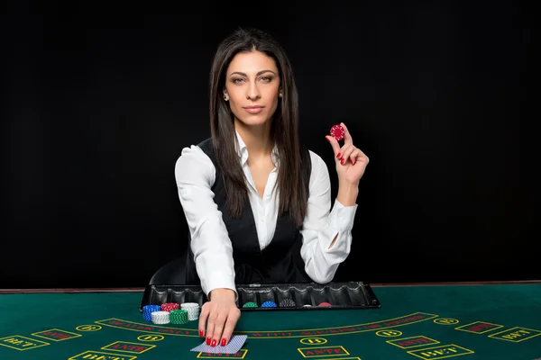 Het mooie meisje, dealer, achter een tafel voor poker — Stockfoto