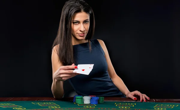La belle fille, dealer, derrière une table de poker — Photo