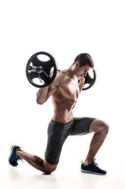 Muscular man standing on knee, holding barbell over his head
