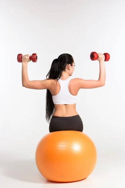 Jeune sportive faisant des exercices de fitness avec haltères sur pilat — Photo