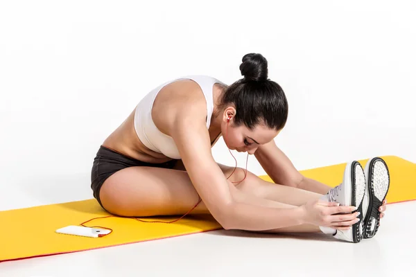 Aantrekkelijke vrouw doen oefeningen. Brunette fit lichaam op yoga mat — Stockfoto