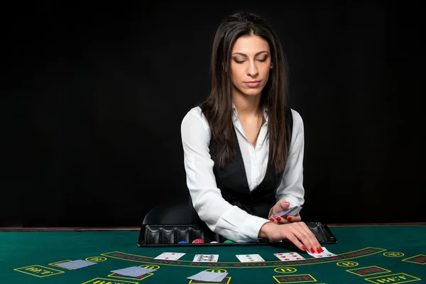 Το όμορφο κορίτσι, έμπορος, πίσω από ένα τραπέζι για το πόκερ — Φωτογραφία Αρχείου