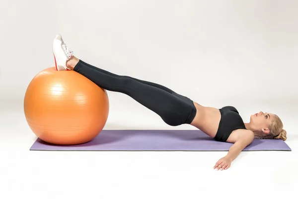 Mujer joven entrenando con fitball — Foto de Stock