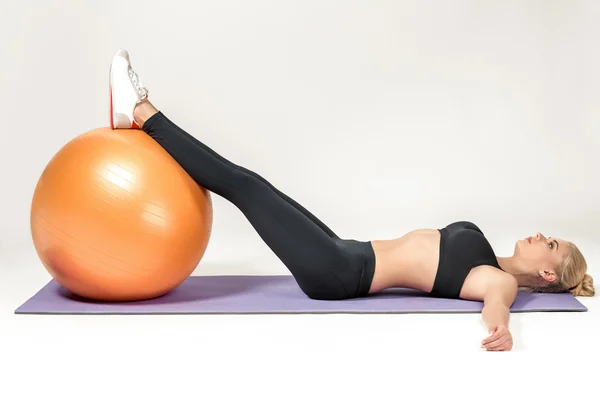 Jovem mulher treinando com fitball — Fotografia de Stock