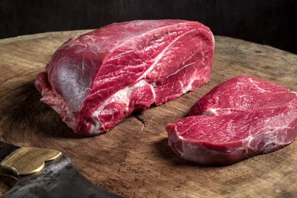 나무 테이블에 육즙이 원시 쇠고기 스테이크 — 스톡 사진
