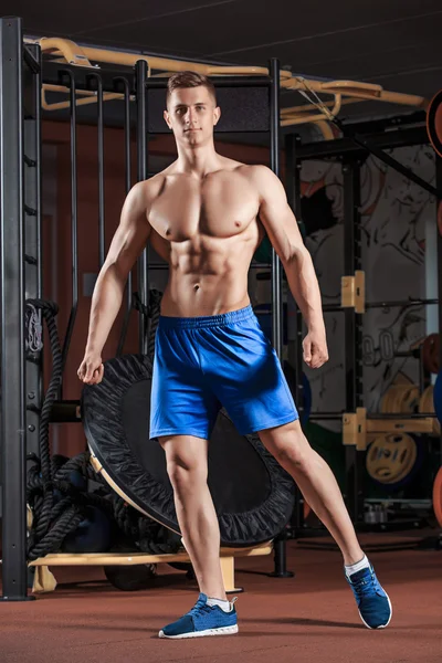 Man standing strong in the gym and flexing muscles — Stock Photo, Image