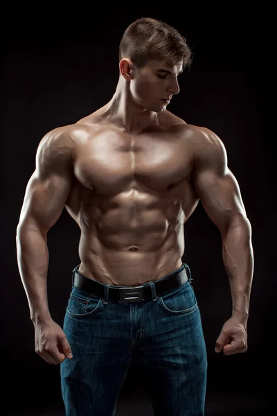 Muscular culturista chico haciendo posando sobre fondo negro — Foto de Stock