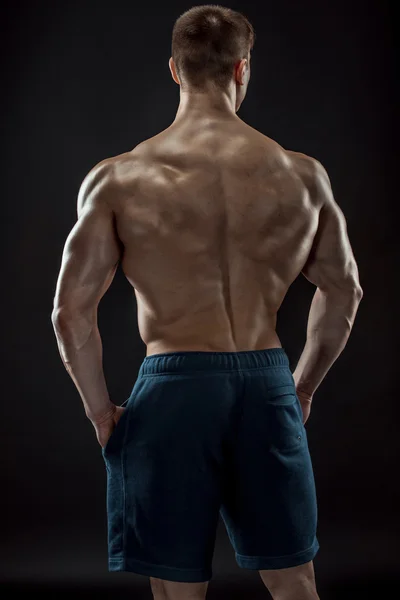 Muskulöse Bodybuilder Kerl tun posieren über schwarzem Hintergrund — Stockfoto