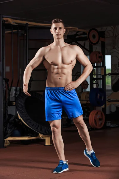 Ο άνθρωπος στέκεται ισχυρή στο γυμναστήριο και να επιδεικνύουμε δύναμη — Φωτογραφία Αρχείου