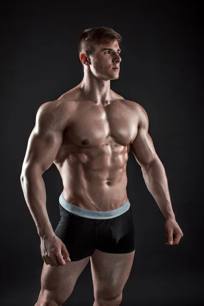 Siyah arka plan üzerinde poz yapan kaslı vücut geliştirmeci adam — Stok fotoğraf