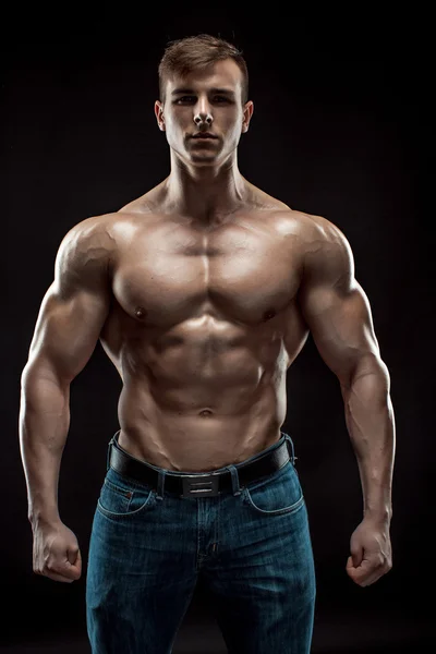 Muscular bodybuilder guy doing posing over black background — Stock Photo, Image
