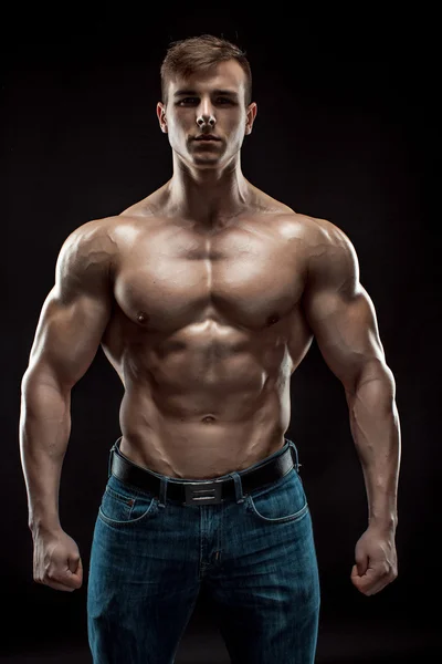 Muscular culturista chico haciendo posando sobre fondo negro — Foto de Stock