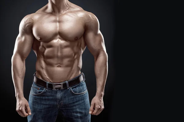 Muscular bodybuilder guy doing posing over black background — Stock Photo, Image