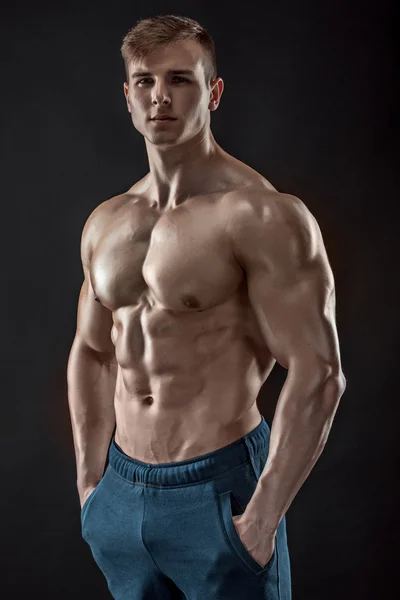 Muscular culturista chico haciendo posando sobre fondo negro —  Fotos de Stock