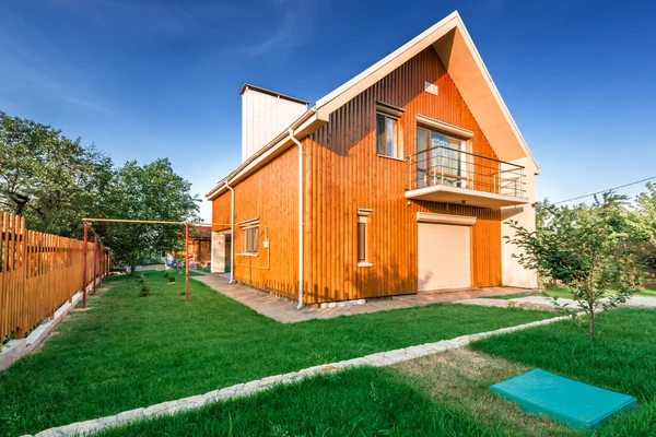 Drewniany dom z łąka przed nim — Zdjęcie stockowe