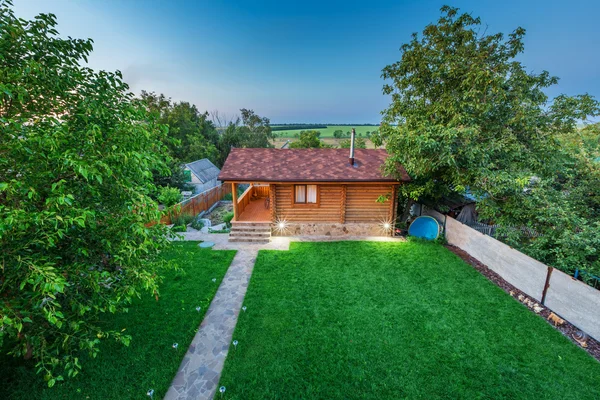 Wooden house with meadow in front of it — Stock Photo, Image